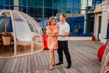 a man and a woman in love dance to a rooftop cafe on a date.