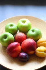 Wooden bowl with various colorful fruit. Selective focus.