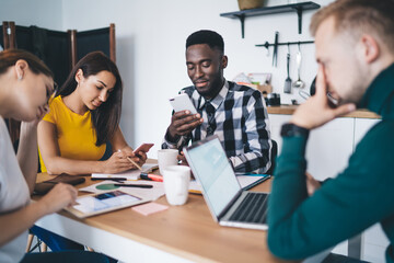 Fototapeta premium Serious coworkers using various gadgets at work