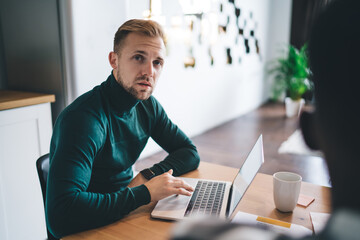 Young man working on laptop in modern workspace