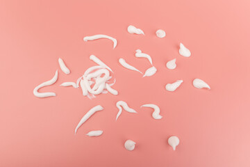 Obraz premium White cosmetic cream smear isolated on pink background. Skincare product creamy texture.