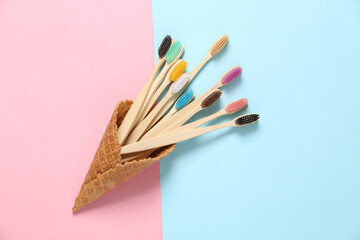 Eco toothbrushes in a waffle cone on a blue-pink background. Creative dental care layout