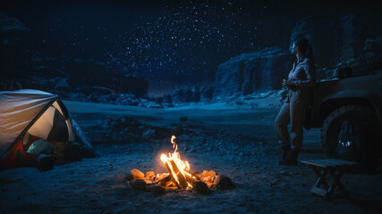 Female Traveler Watching Night Sky while Camping in the Canyon by Campfire. Amazing Campsite view...