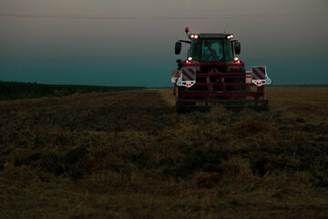 combine harvester in the field at evening