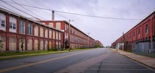 Paved empty street and old fashioned red brick factory buildings