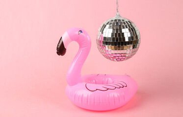 Inflatable flamingo under disco ball on pink background. Minimalism party concept