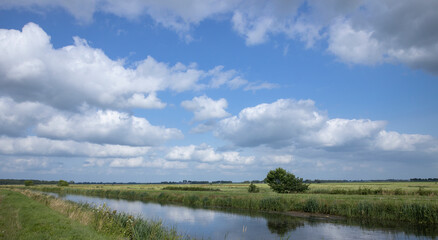 Fototapeta na wymiar Havelte Oude Vaart Drente Netherlands. Canal and meadows. Dutch landscapes. Clouds. Summer