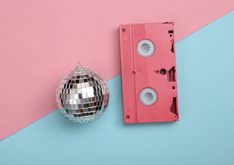 Disco ball with retro video cassette on blue pink background. Minimalism party concept