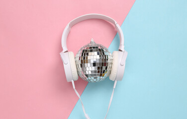 Headphones with Disco ball on blue pink background. Minimalism party concept