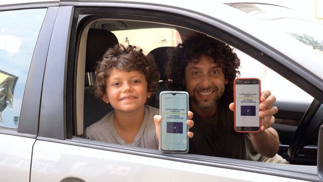 Europe, Italy , Green Pass European Eu Digital Covid-19 Coronavirus passport Certificate to travel - Father and son boy 7 years old ready to go on a trip with screenshots of the vaccination
