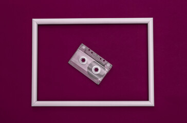 Obraz premium Retro audio cassette on purple background with white frame. Top view