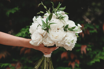White bridal bouquet of peonies and roses. Scenery for the wedding.