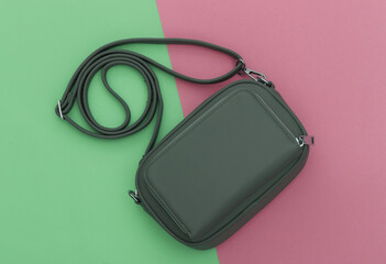 Fashionable leather bag on pink green pastel background. Top view.