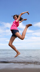 girls jump big smiling and happy by the sea in summer