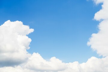 Naklejka na ściany i meble White large fluffy clouds frame a clear blue sky