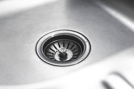 A stainless steel kitchen sink drain close-up view photo