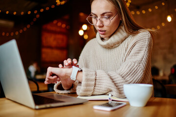 Wistful woman touching screen of smart watch