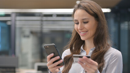 Fototapeta na wymiar Portrait of Young Businesswoman with Successful Online Shopping on Smartphone