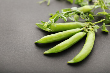 Green pea pods on black background