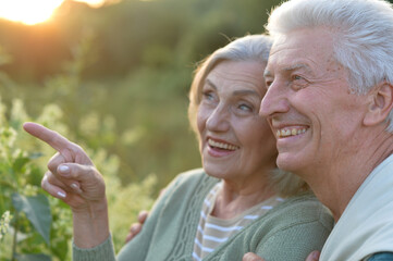 Fototapeta premium senior couple posing in the park, man pointing with finger