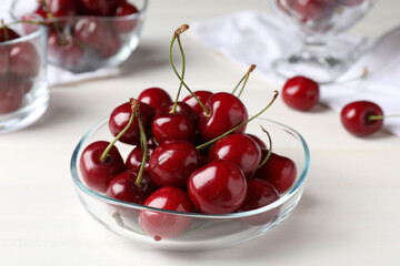 Sweet red cherries in bowl on white wooden table, closeup - Powered by Adobe