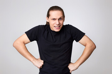angry man in black t-shirt isolated on gray background