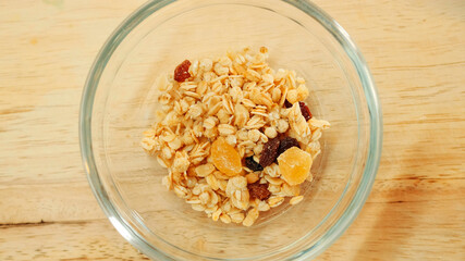 Pouring muesli breakfast mix in bowl. Close up shot