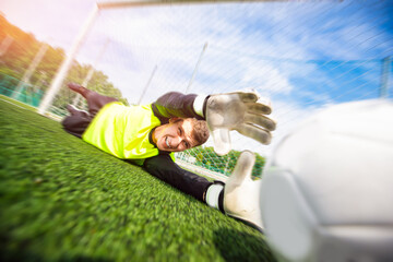 action moment of sport Goalkeeper soccer man catching ball in stadium
