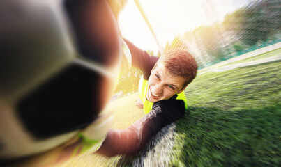 Goalkeeper soccer man catching ball in stadium, action sport moment
