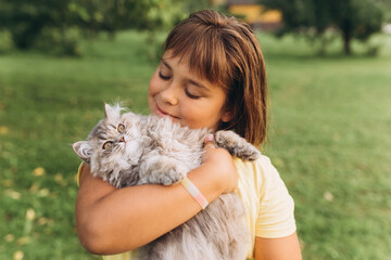 Portrait with kitten in park. Girl play outdoors with cat