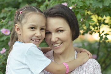 Happy mother and daughter posing in the park