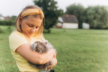 Portrait with kitten in park. Girl play outdoors with cat