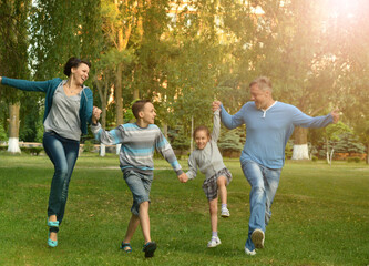 Happy young family running in summer park