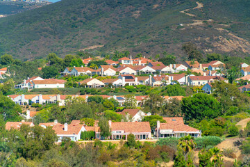 Beautiful view of house buildings with tiled rooftops surrounded by trees on a sunny summer day