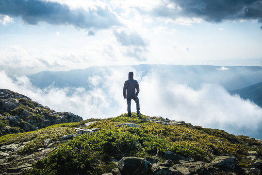 man on mountaintop looking at the horizon