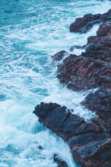 Choque de olas contra las piedras al lado de la playa