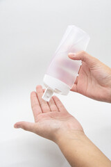 Hands using a plastic bottle of sanitizer