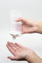 Hands using a plastic bottle of sanitizer