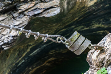 Stainless steel rope and bow rope clamps stretched between the rocks. This technique is used in industry, construction and architectural structures.  - 447501514