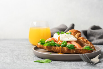 Morning breakfast with croissant, salmon, spinach and poached egg. Healthy Snack Fish Sandwich