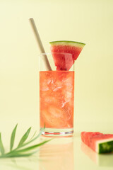 Watermelon drink in glass on green pastel background. Summer tropical refreshing cocktail