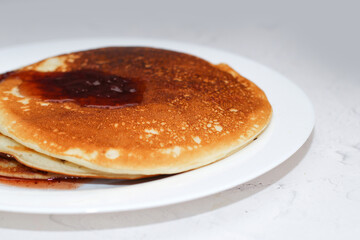 Pancakes in a snow-white plate. Rosy hot sweet breakfast.