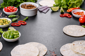 Mexican tacos with beef, tomatoes, avocado, onion and salsa sauce