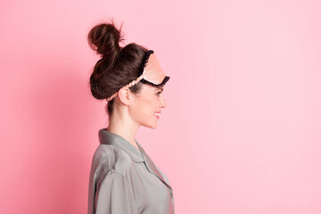 Profile side view of attractive cheerful girl wearing pajama copy empty space ad isolated over pink pastel color background