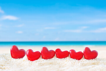 red heart shape on white sand beach 
