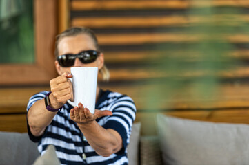 woman giving white mug with copy space, closeup