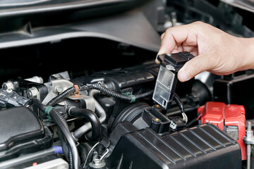 Close up hand a Technician remove airflow sensor in the engine room car for check and cleaning in...