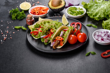Mexican tacos with beef, tomatoes, avocado, onion and salsa sauce