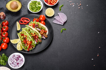 Mexican tacos with beef, tomatoes, avocado, onion and salsa sauce