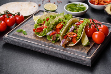 Mexican tacos with beef, tomatoes, avocado, onion and salsa sauce